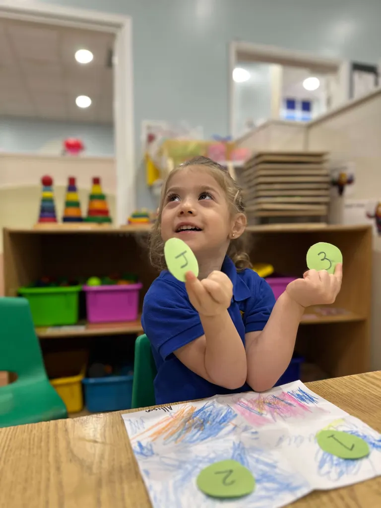 Una niña mostrando orgullosa su obra hecha con sellos